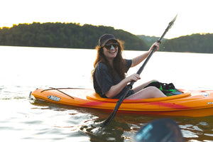 Woman kayaking in summer with reef safe sunscreen on her nose.